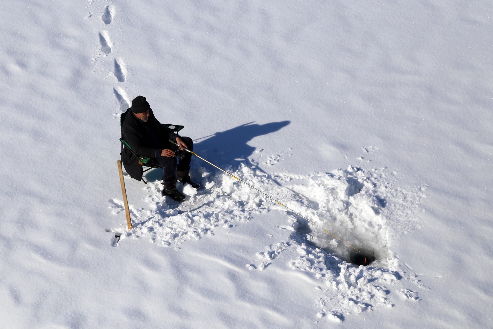 Baraj gölündeki 40 santimlik buzu kazma ile kırıp balık tutuyorlar 7