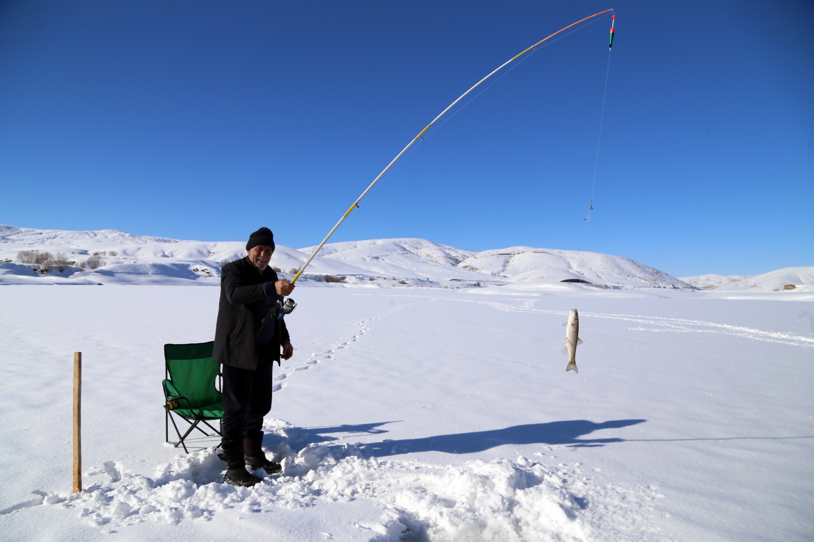 Baraj gölündeki 40 santimlik buzu kazma ile kırıp balık tutuyorlar 6