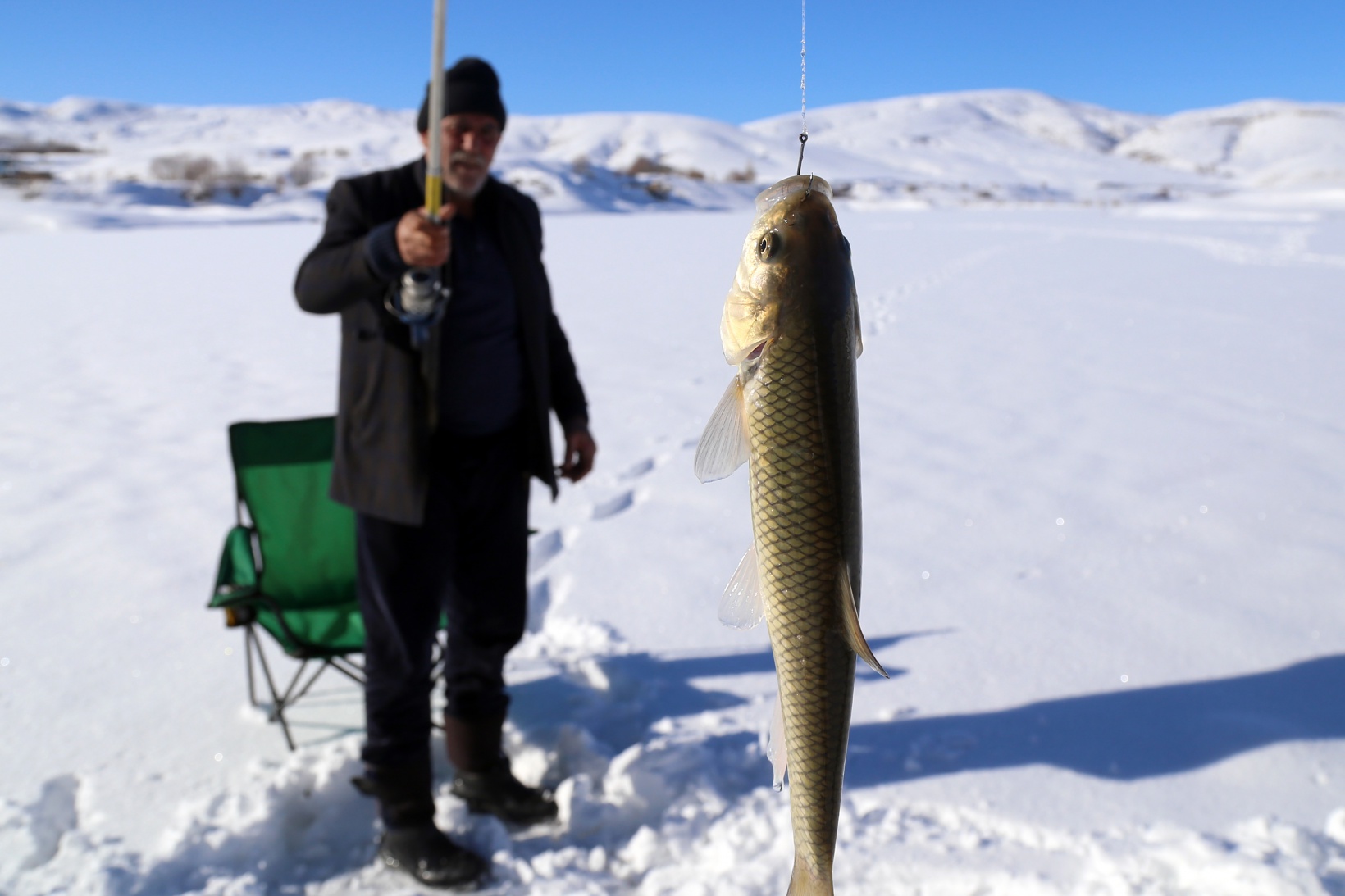 Baraj gölündeki 40 santimlik buzu kazma ile kırıp balık tutuyorlar 2