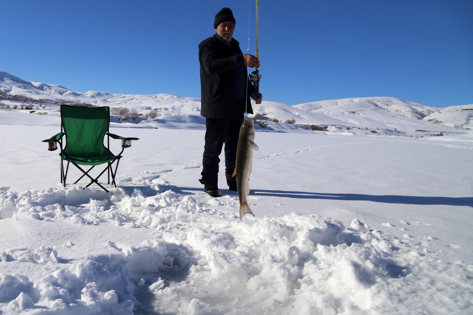 Baraj gölündeki 40 santimlik buzu kazma ile kırıp balık tutuyorlar 12